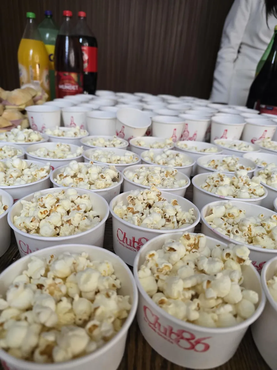 Vasos de palomitas con el logotipo de Club 86 durante la celebración de apertura